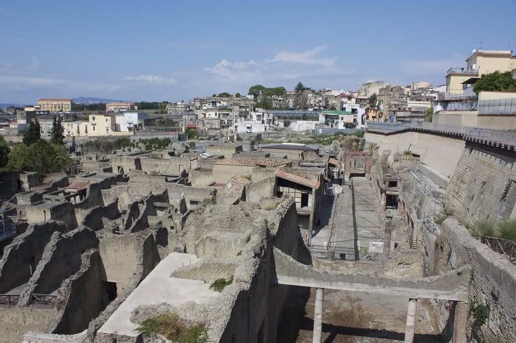 Preserved Roman buildings and excavated streets at the Herculaneum archaeological site below Mount Vesuvius.